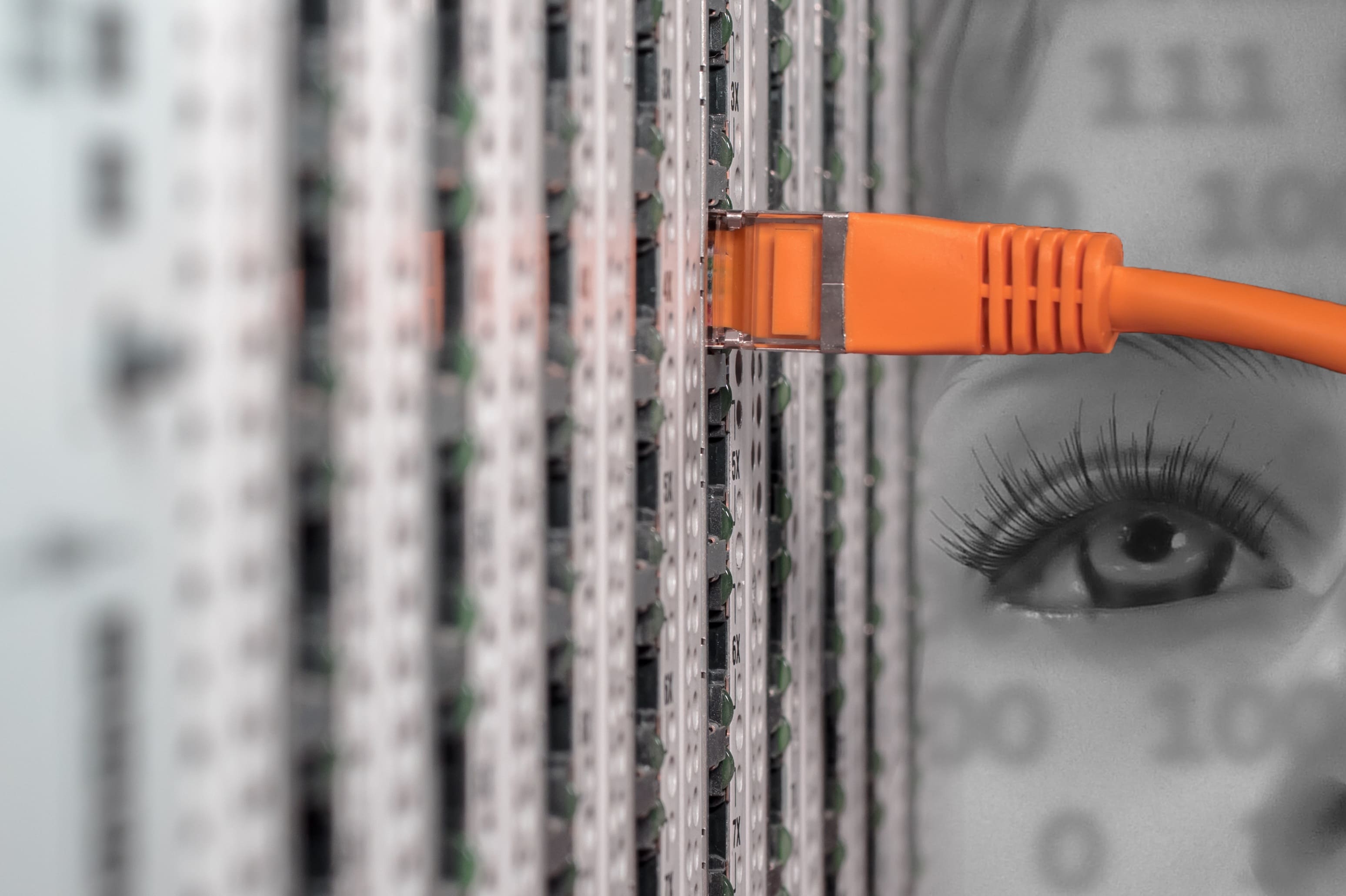 Bild eines einzelnen orangenen Netzwerkkabels in einem Serverport